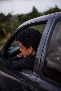 Man looking through car window