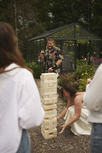 Friends playing giant jenga in garden