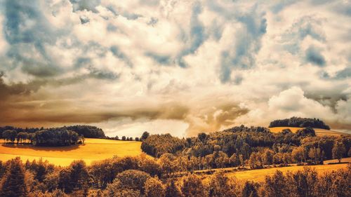 Scenic view of field against cloudy sky