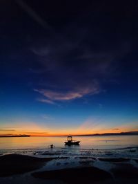 Scenic view of beach against sky at sunset