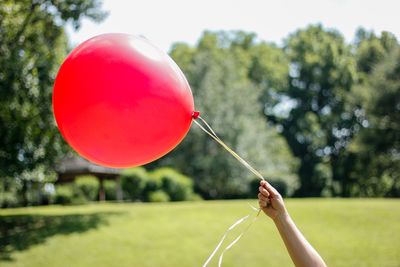 Close-up of hand holding red balloon