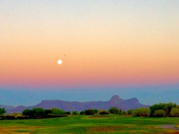 Scenic view of field against clear sky at sunset