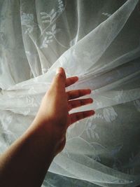 Close-up of woman hand on bed