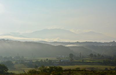 Scenic view of field and mountains against sky