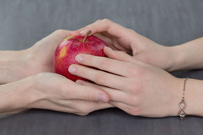 Close-up of hands holding apple