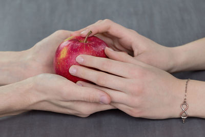 Midsection of woman holding apple