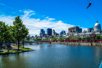 City at waterfront against blue sky