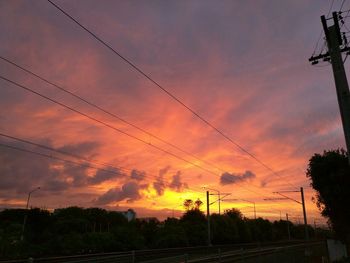 Electricity pylon against cloudy sky