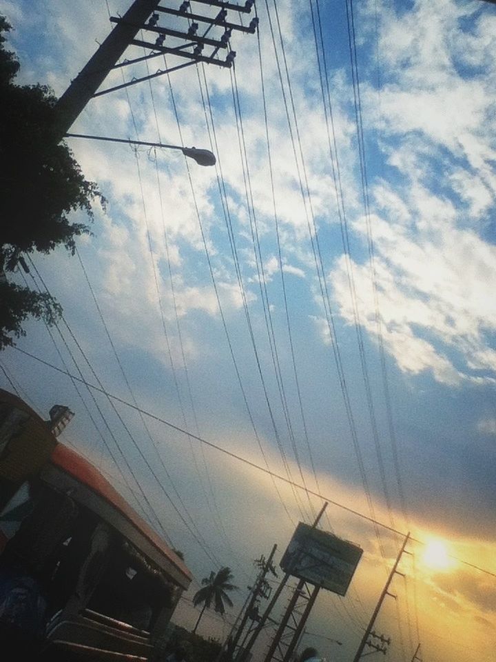 sky, power line, electricity pylon, electricity, cloud - sky, low angle view, building exterior, built structure, technology, power supply, architecture, fuel and power generation, cable, silhouette, sunset, connection, cloud, cloudy, city, dusk