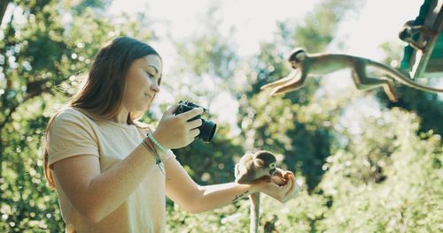 Side view of young woman holding plants