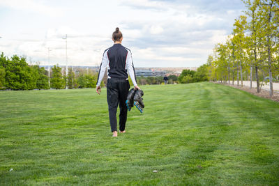 Rear view of man walking on field