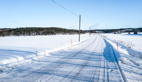 Snow covered landscape against clear sky