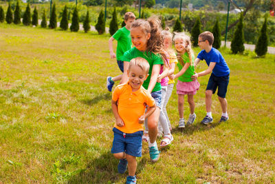 Full length of a boy smiling while standing on grass