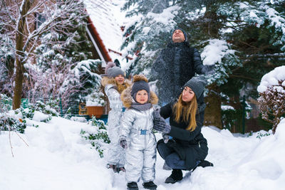 Attractive family having fun in winter park. parents spend time outdoors