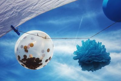 Low angle view of balloons against blue sky