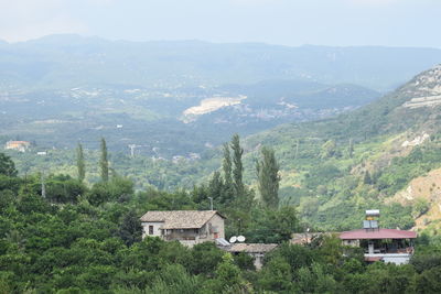 Scenic view of trees and houses against mountains