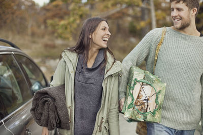 Couple carrying camping equipment by car