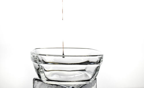 Close-up of drink in glass against white background