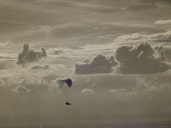 People paragliding over sea against sky