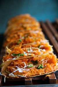 Close-up of tacos on table against wall