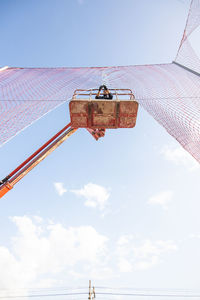 Low angle view of crane against sky