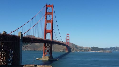 Golden gate bridge over bay of water against clear blue sky