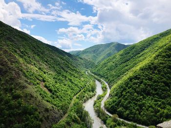 Scenic view of green mountains against sky