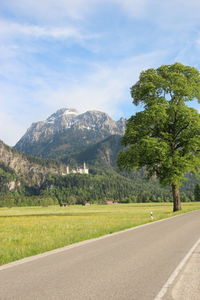 Scenic view of road by mountains against sky