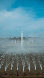 Fountain in sea against sky