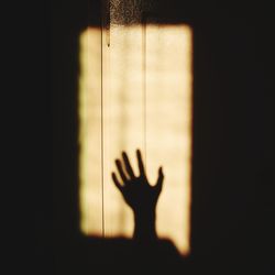 Shadow of person hand on glass window