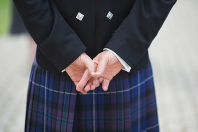 Midsection of woman with hands behind back