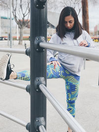 Woman looking at camera while standing on railing