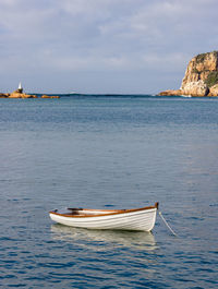 Sailboat moored on sea against sky