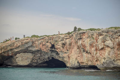 Scenic view of rocks on sea against sky