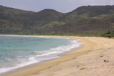 Scenic view of beach and mountains against sky