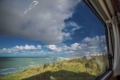 Panoramic view of sea seen through glass window