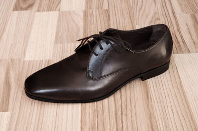 Close-up of leather shoe on hardwood floor