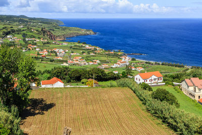 High angle view of buildings and sea against sky