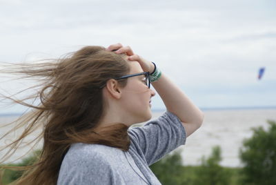 Close-up of young woman against sea