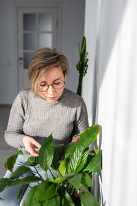 Portrait of a smiling young woman holding plant