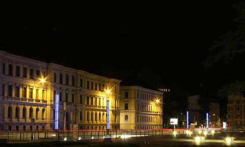 Illuminated city against sky at night