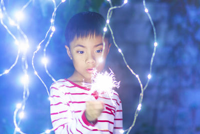 Portrait of woman with fire crackers at night