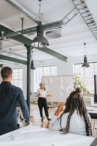 Businesswoman explaining colleagues during meeting at work place