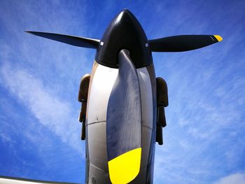 Low angle view of propeller airplane against blue sky