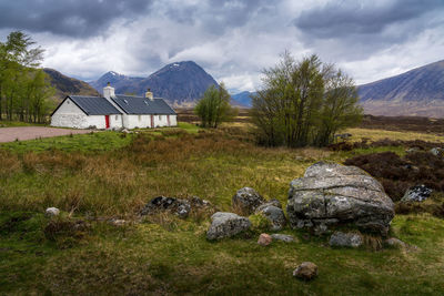 Scenic view of cottage and mountain against sky