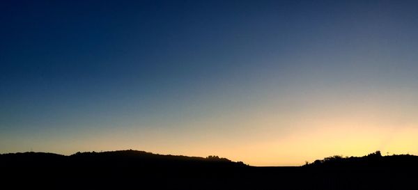 Silhouette trees against sky during sunset