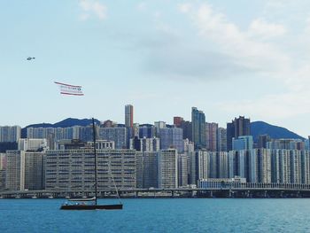 View of sea against modern buildings in city
