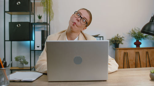 Portrait of woman using laptop at table