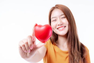 Portrait of a smiling young woman against white background