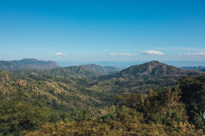 Scenic view of mountains against blue sky